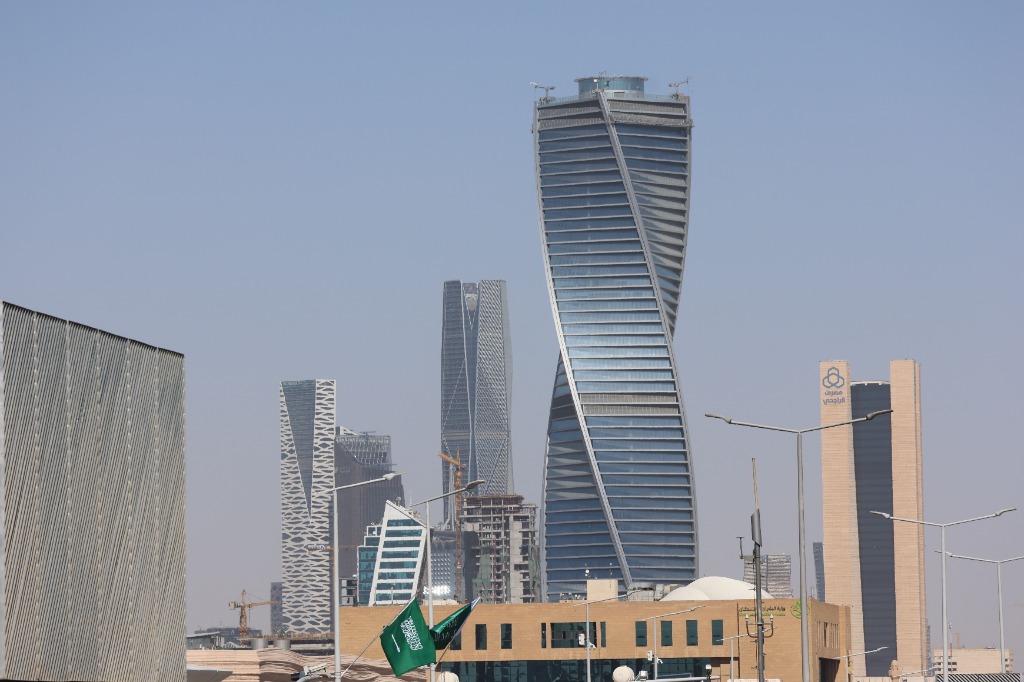 Gratte-ciels de l'immobilier commercial et financier à Riyad, Arabie Saoudite, incluant la tour torsadée signature et le drapeau saoudien flottant au premier plan